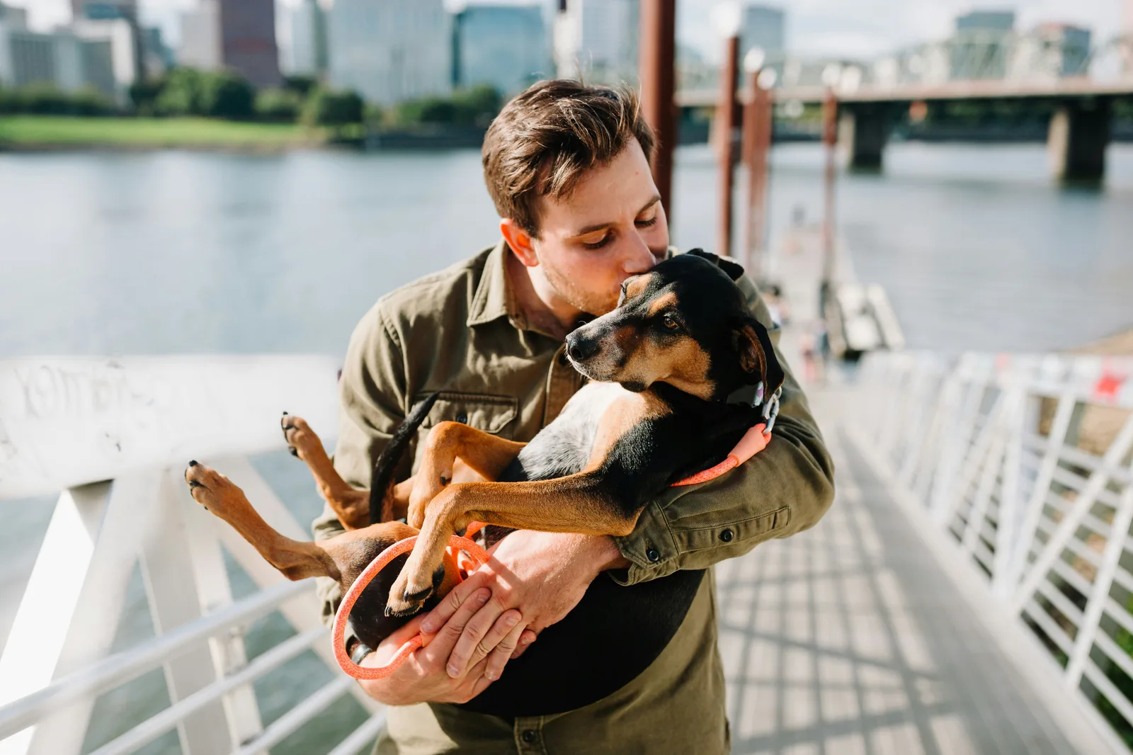 A person embracing a dog cheek-to-cheek
